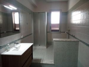 uma casa de banho com um lavatório, um chuveiro e um espelho. em B&B del Capo em Santa Ninfa