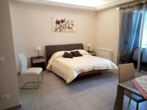 1 dormitorio con 1 cama y 1 silla en B&B del Capo, en Santa Ninfa