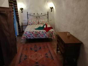 a bedroom with a bed with a doll sitting on it at Cueva Peralta in Cortes de Baza