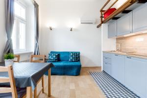 a living room with a blue couch and a table at Flexible SelfCheckIns 13 & 14 - Le Petit & Le Grand Zagreb - Centre - New - Apartments Repinc in Zagreb