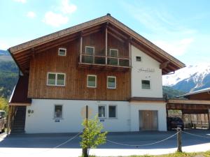 a large building with a wooden roof at ff Appartements in Bramberg am Wildkogel