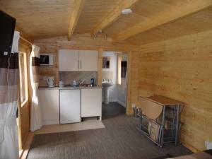 una cocina en una cabaña de madera con mesa y sillas en Homeside B&B en Silverstone
