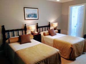 Una habitación con dos camas y dos mesas con lámparas. en Aran View Country House and Lodge, en Doolin
