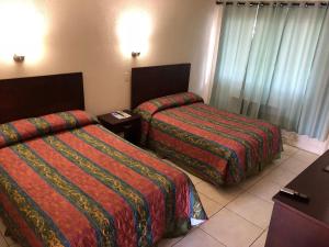 a hotel room with two beds in a room at Sunset Inn- Fort Pierce, FL in Fort Pierce