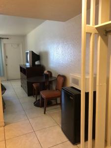 a living room with a desk and a table and chairs at Sunset Inn- Fort Pierce, FL in Fort Pierce