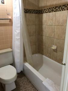 皮爾斯堡的住宿－Sunset Inn- Fort Pierce, FL，浴室配有卫生间、浴缸和水槽。