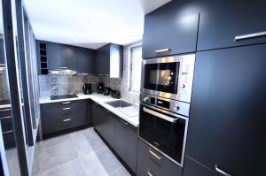 a kitchen with black cabinets and a stove top oven at Au Selaou 34 in Val Thorens