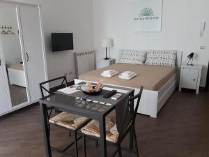 1 dormitorio con 1 cama y 1 mesa con sillas en Pirtuso Del Porto, en Palermo