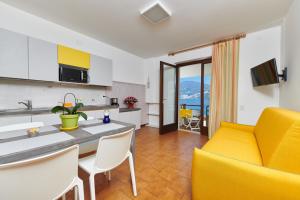 una cucina e un soggiorno con divano giallo di Residence Mariù a Malcesine