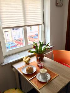 a table with a plate of food and a cup of coffee at Ferienwohnung Lilly in Wittenberge