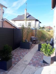 a backyard with a black fence and potted plants at Le cosy plage in Ouistreham