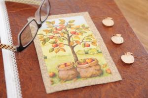 a table with a picture of an apple tree and glasses at Urbanhof Prantenberger in Bolzano