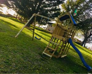 a playground with a slide and a swing at Agriturismo Podere Campinovi in Colle Val D'Elsa