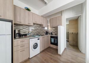 a kitchen with a washing machine and a washer at Pebble Beach Holiday Apartments in Limassol