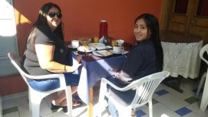 two women sitting at a table eating food at Hostal Lluvia de Oro in Arequipa