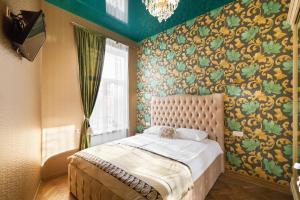 ein Schlafzimmer mit einem Bett in einem Zimmer mit Tapete in der Unterkunft Austrian Apartments in Lwiw