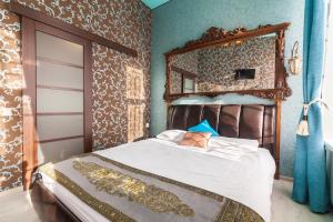a bedroom with a bed with a mirror on the wall at Austrian Apartments in Lviv