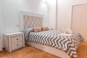 グラナダにあるApartamento Completo Pernaleros Centroの白いベッドルーム(ベッド1台、白黒の掛け布団付)