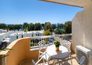 een patio met een tafel en stoelen op een balkon bij Pebble Beach Holiday Apartments in Limassol