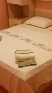 una pila de toallas plegadas sentadas en una cama en Apartments Vrisika-family apartment, en Makarska