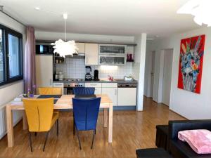 een keuken en eetkamer met een houten tafel en stoelen bij Panorama-Übernachtungen in Biberach-Ummendorf