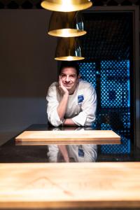 a man standing behind a counter with a light above him at Hotel Ristorante Eurossola in Domodossola