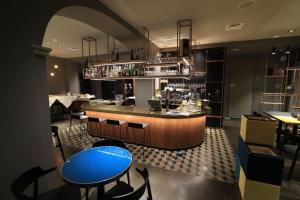 a restaurant with a bar with blue tables and chairs at Hotel Ristorante Eurossola in Domodossola