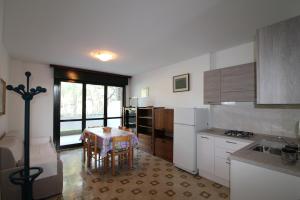 eine Küche mit einem Tisch und einem Esszimmer in der Unterkunft Appartamenti Meridiana in Lignano Sabbiadoro