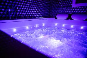 een jacuzzi met verlichting in een kamer bij Suite Glamour & Spa in Dijon