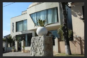 a building with a statue in front of it at Amore Hotel in Gudauta