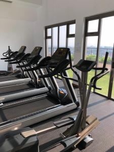 a row of treadmills in a gym with windows at Hedges Court Residencies Town Hall- 2 Bed Room Apartment in Colombo