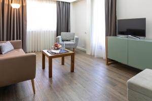 a living room with a couch and a tv and a table at Hotel Black Tulip - Porto Gaia in Vila Nova de Gaia