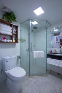 a bathroom with a toilet and a glass shower at Antique Angel Hotel in Hanoi