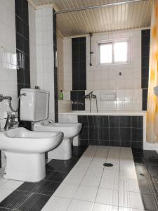 a bathroom with a toilet and a sink and a tub at Villa Erasmia in Dhékarkhon