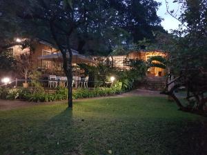 a house with a lawn in front of it at night at Shingalana Guest House in Hazyview