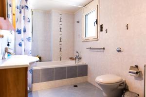 Un baño con bañera, inodoro y lavabo. en Promachon Villa, en Foinikiá 17 fotos más