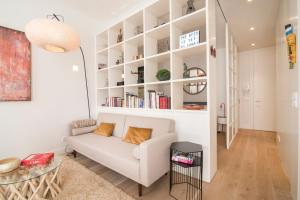 salon z białą kanapą i półkami na książki w obiekcie Lisbon Rouge Apartment in the Lisbon Heart w Lizbonie