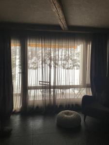 a room with a window with a chair and a rug at Charly Studio In Gstaad in Gstaad