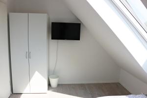 a bedroom with a tv on the wall in the attic at Dornfelder in Hanhofen