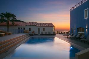 a villa with a swimming pool in front of a house at Best Western Premier Santa Maria in LʼÎle-Rousse