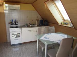 a kitchen with a table and a sink and a stove at Ferienwohnung Sommer in Friedrichsbrunn