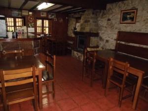 a kitchen with wooden tables and chairs and a stove at El Molino in Arenas de Cabrales