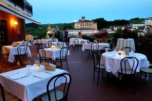 ein Restaurant mit weißen Tischen und Stühlen und Aussicht in der Unterkunft Hotel Barolo Classico in Barolo