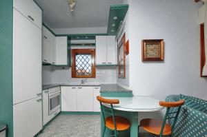 a kitchen with white cabinets and a table and chairs at Seaside Vourvourou Villa in Vourvourou