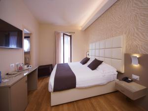 une chambre d'hôtel avec un grand lit et une cuisine dans l'établissement Hotel Dori, à Peschiera del Garda
