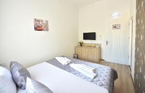 - une petite chambre avec un lit et une télévision dans l'établissement Villa Nina Hotel & Lounge bar, à Skopje
