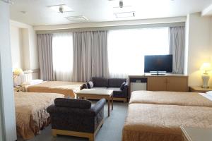 Habitación de hotel con 2 camas y TV de pantalla plana. en Urayasu Beaufort Hotel, en Urayasu