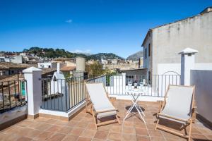 a patio with two chairs and a table on a balcony at Townhouse on the rocks By homevillas360 in Pollença