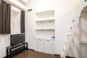 uma sala de estar com armários brancos e uma televisão em Midtown Center Apartments em Zadar