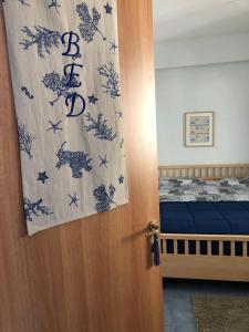 - une chambre avec un lit et une porte avec un rideau dans l'établissement Light Blue House, à Letojanni